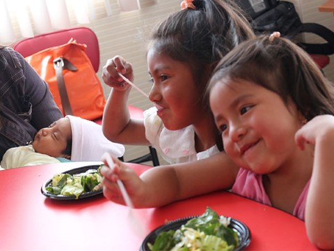 Dos niñas en Ecuador comen la ensalada y les gusta.