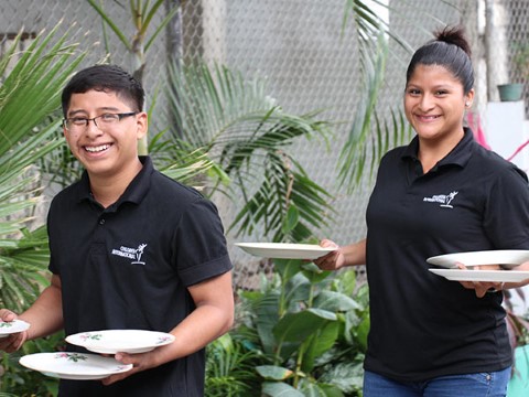  Jóvenes practican ser camareros como parte de su capacitación en hospitalidad.