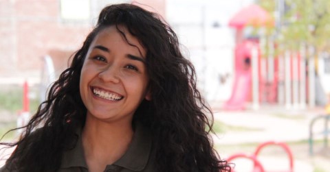 una mujer con cabello largo y negro sonriendo a la cámara