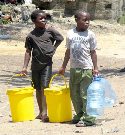 Dos niños en Lusaka caminan largos trechos en busca de agua