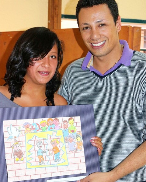 Pedro y la apadrinada Yessenia con la ilustración que presentó para el concurso de arte de Children International