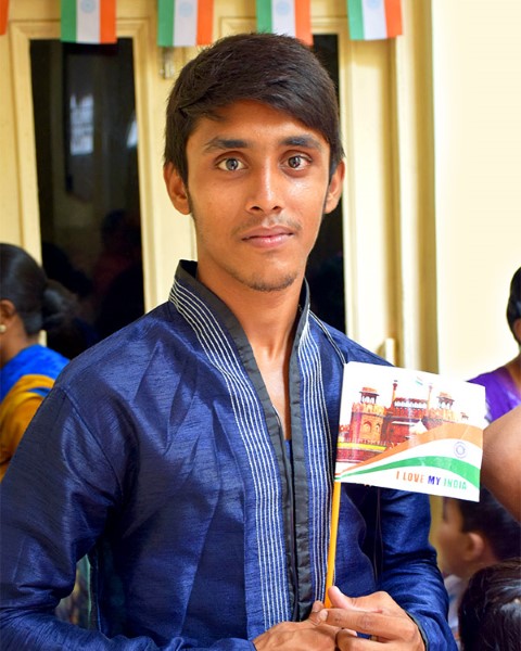 Teen in blue holding paper Indian flag