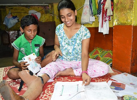 Nisha ayuda a su hermano menor, Sumit, con sus tareas.