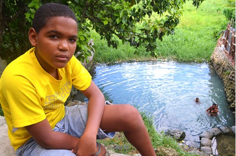 Children in poverty swim in a dangerous water well.