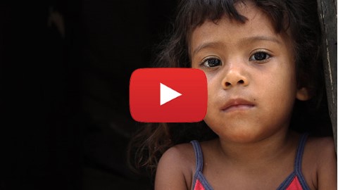 una niña con una camiseta roja mirando a la cámara