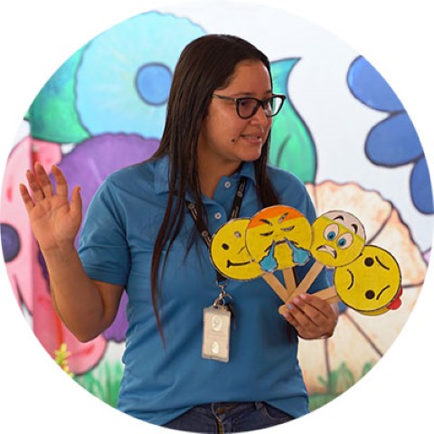 a woman in a blue shirt holding emotion cards