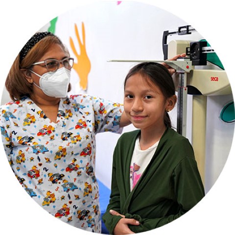 a woman standing next to a little girl in a clinic