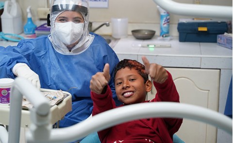 una mujer y un niño en el sillón del dentista