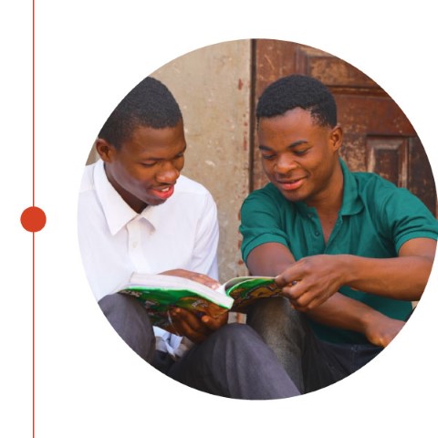 two young men reading a book together