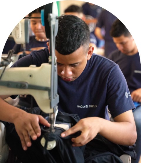 a young man working on a sewing machine