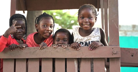 un grupo de niños parados encima de una estructura de madera			