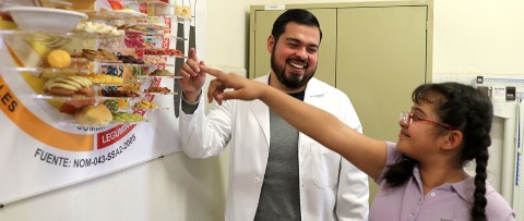 Volunteer teaches a young girl about healthy eating habits