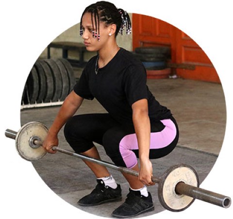 Young woman gets ready to lift heavy weights