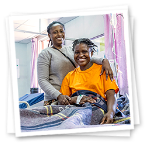 a young girl in a hospital with a woman hugging her