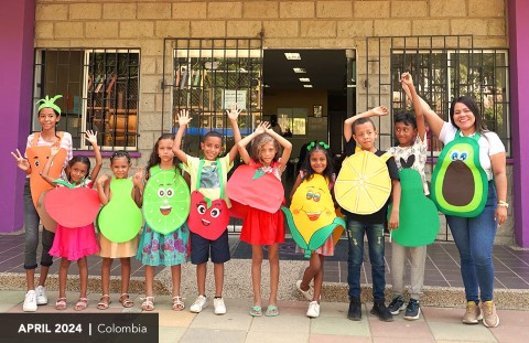 Kids in costumes pose in front of the community center