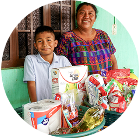 a woman standing next to a boy with donated food