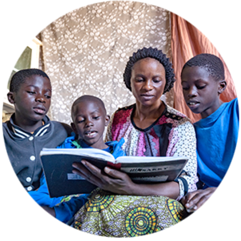 a family sitting on a sofa reading a book