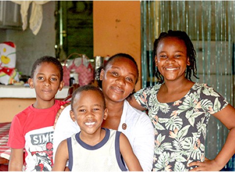 a family smiling in their house