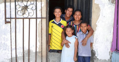 a family standing outside of their home